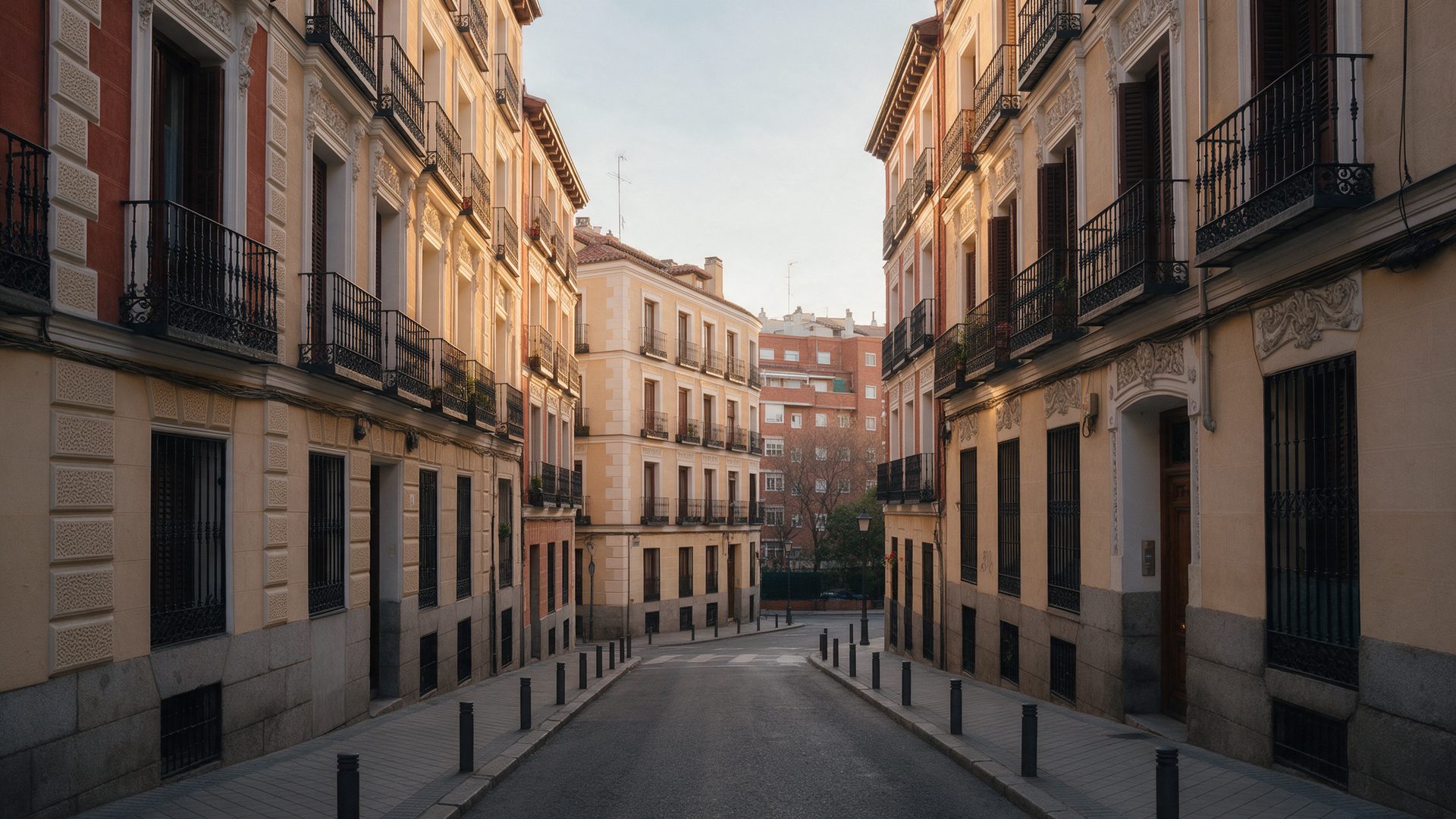Calle residencial de Madrid con fachadas clásicas y balcones de forja al atardecer