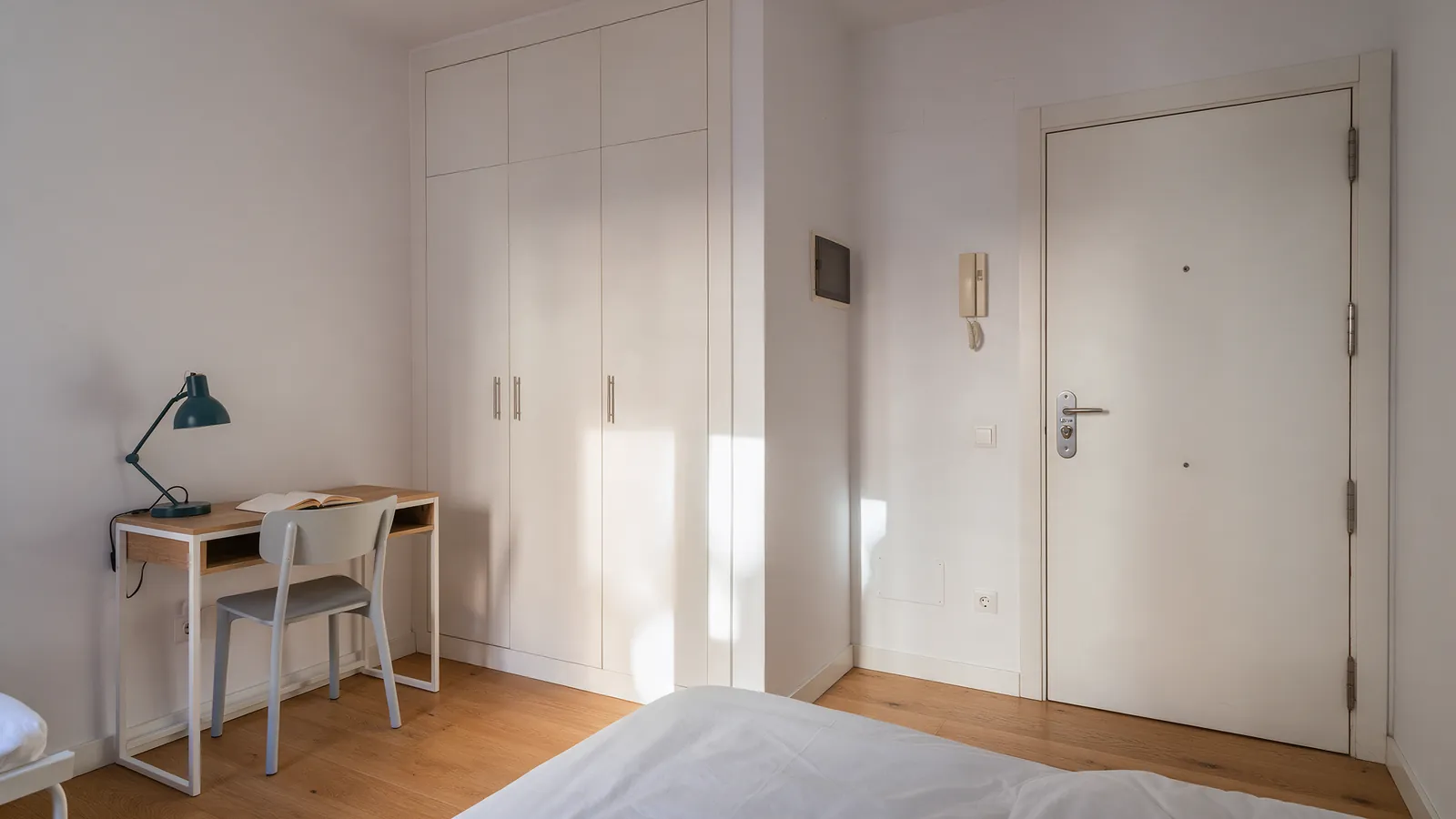 Habitación de coliving terminada en un piso de Madrid, con parqué, armario empotrado y cerradura nueva